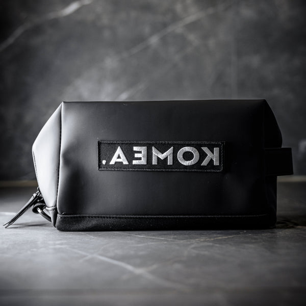 Musta KOMEA toilettilaukku suljettuna kylpyhuoneen tasolla